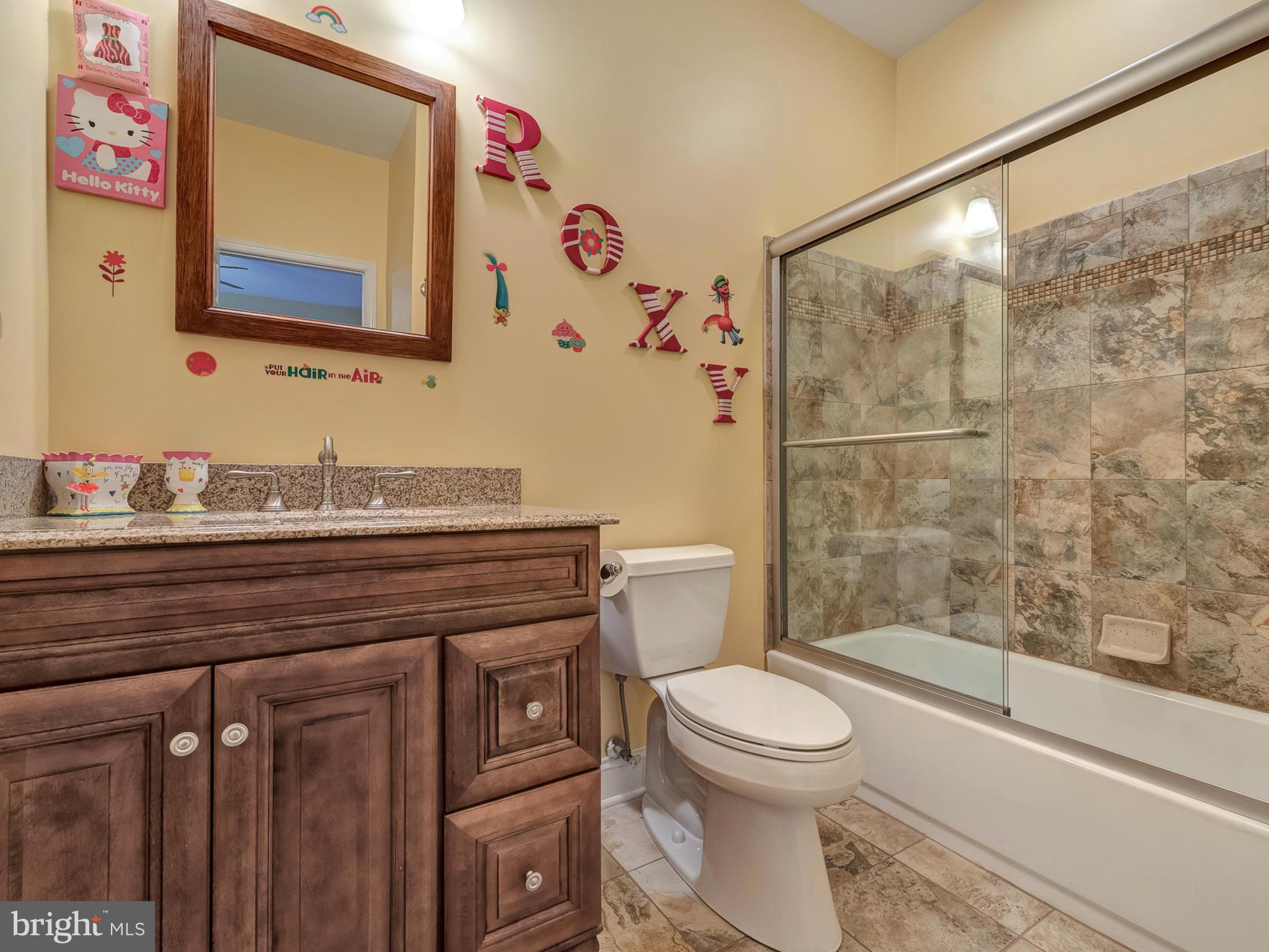 4947 Old Swimming Pool Road Frederick, MD 21703 - Photo 36 of 72 a bathroom with a granite countertop sink a toilet and a bathtub
