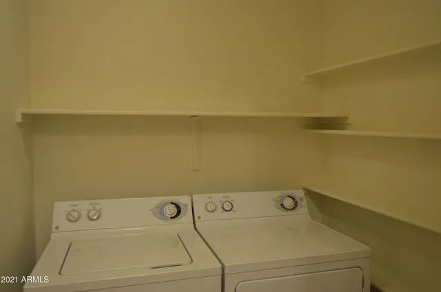 a view of an empty room with chandelier fan
