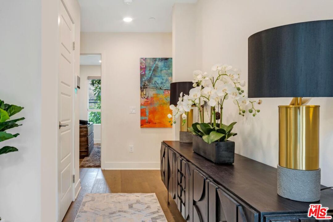 2776 Wright Lane Los Angeles, CA 90068 - Photo 3 of 16 a dining room with stainless steel appliances furniture a potted plant and a wooden floor