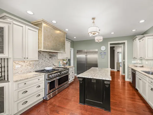 a kitchen with stainless steel appliances granite countertop a stove a sink and a refrigerator