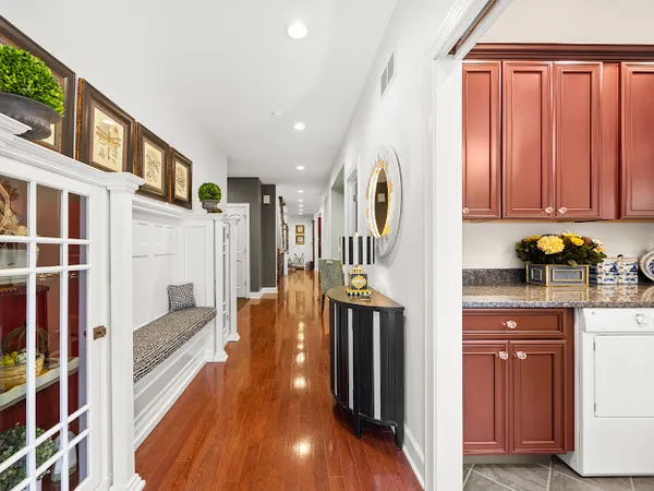 a hallway with stainless steel appliances granite countertop a refrigerator and a wooden floors