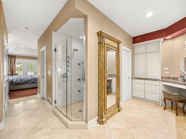 a view of a hallway with bathroom and glass door shower
