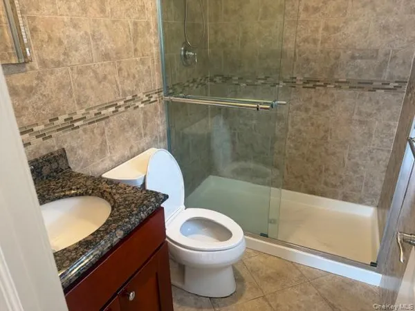 a bathroom with a granite countertop sink a toilet and bathtub