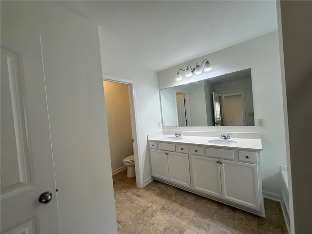 a spacious bathroom with a double vanity sink and mirror