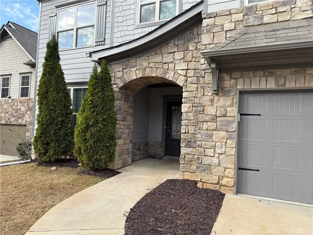 a front view of a house with plants