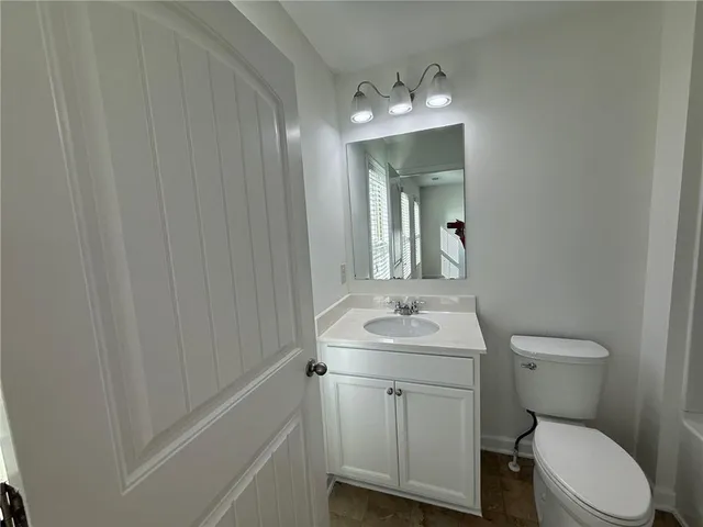 a bathroom with a toilet a sink and mirror
