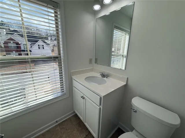 a bathroom with a toilet sink and window