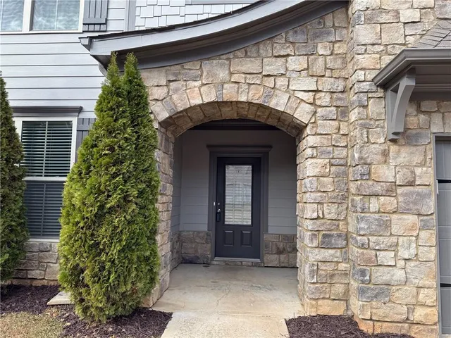 a front view of a house with plants