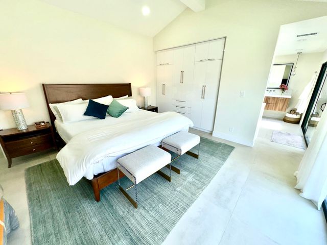 a spacious bedroom with a bed and a rug