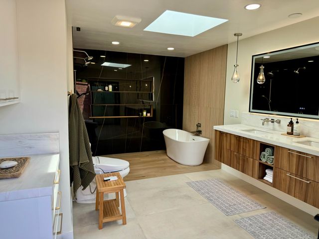 a bathroom with a double vanity sink a mirror and bathtub