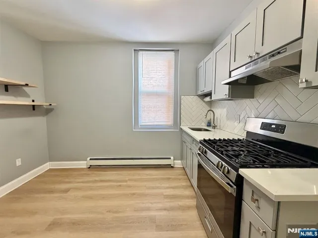 a kitchen with granite countertop a stove and a sink