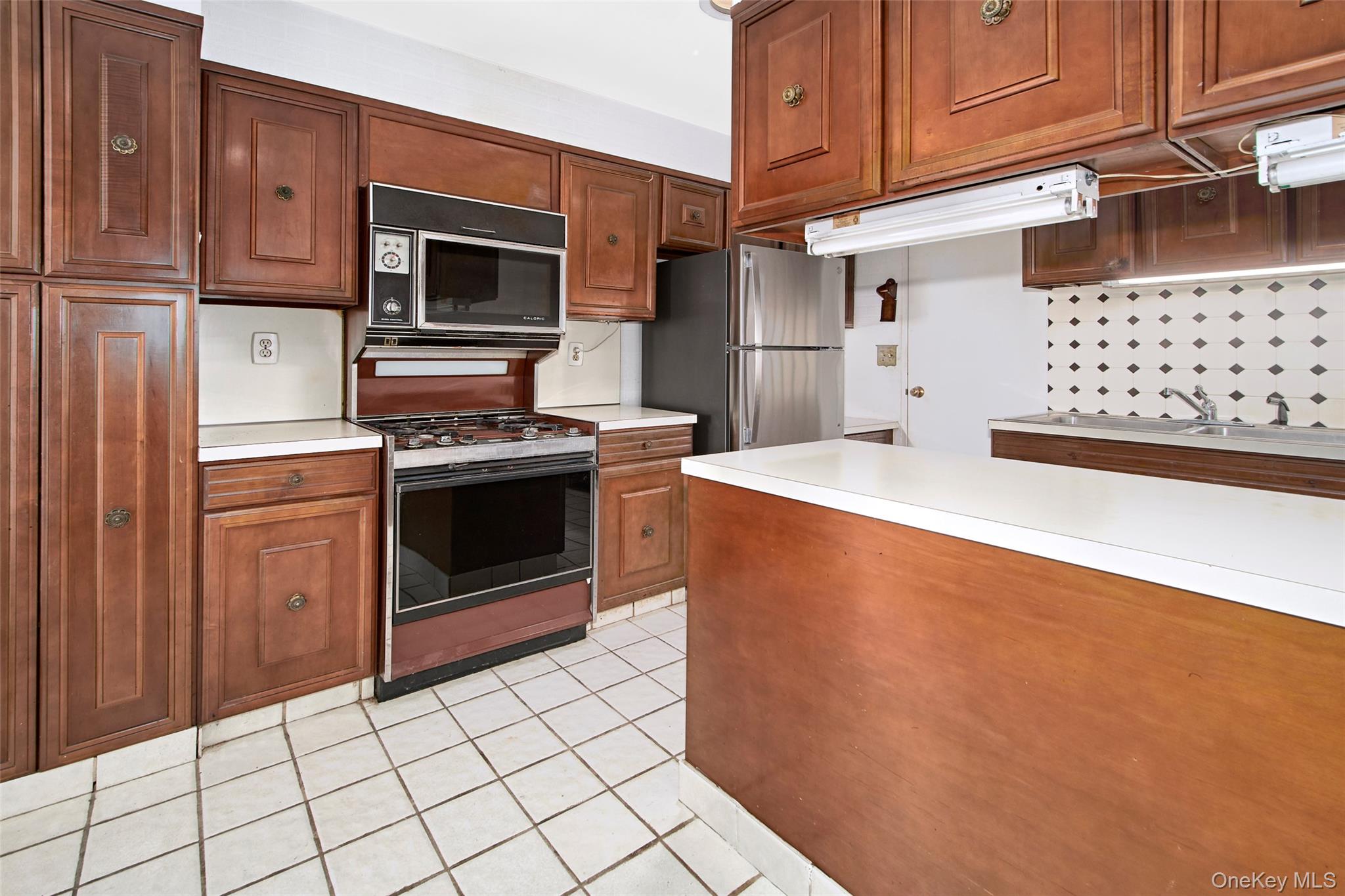 720 Milton Road, Unit 4C WEST Rye, NY 10580 - Photo 18 of 21 a kitchen with stainless steel appliances granite countertop a stove a refrigerator and a microwave