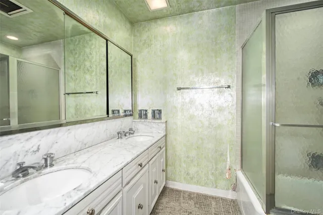 a bathroom with a granite countertop shower sink and mirror