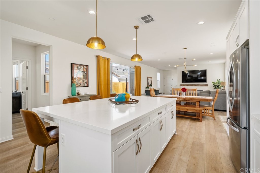 a large kitchen with stainless steel appliances a stove a chimney a sink and a chandelier