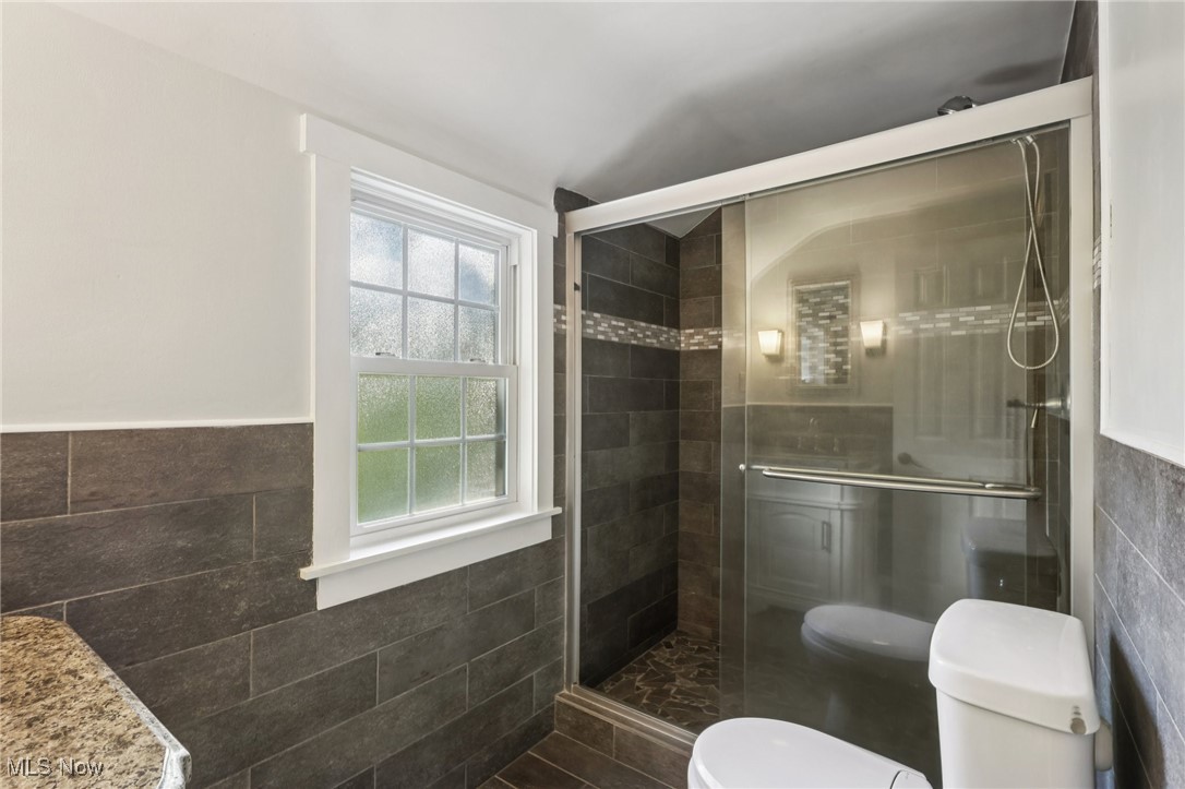 1151 Croyden Road Lyndhurst, OH 44124 - Photo 26 of 37 Full bath with tile walls, wainscoting, a shower stall, and vanity