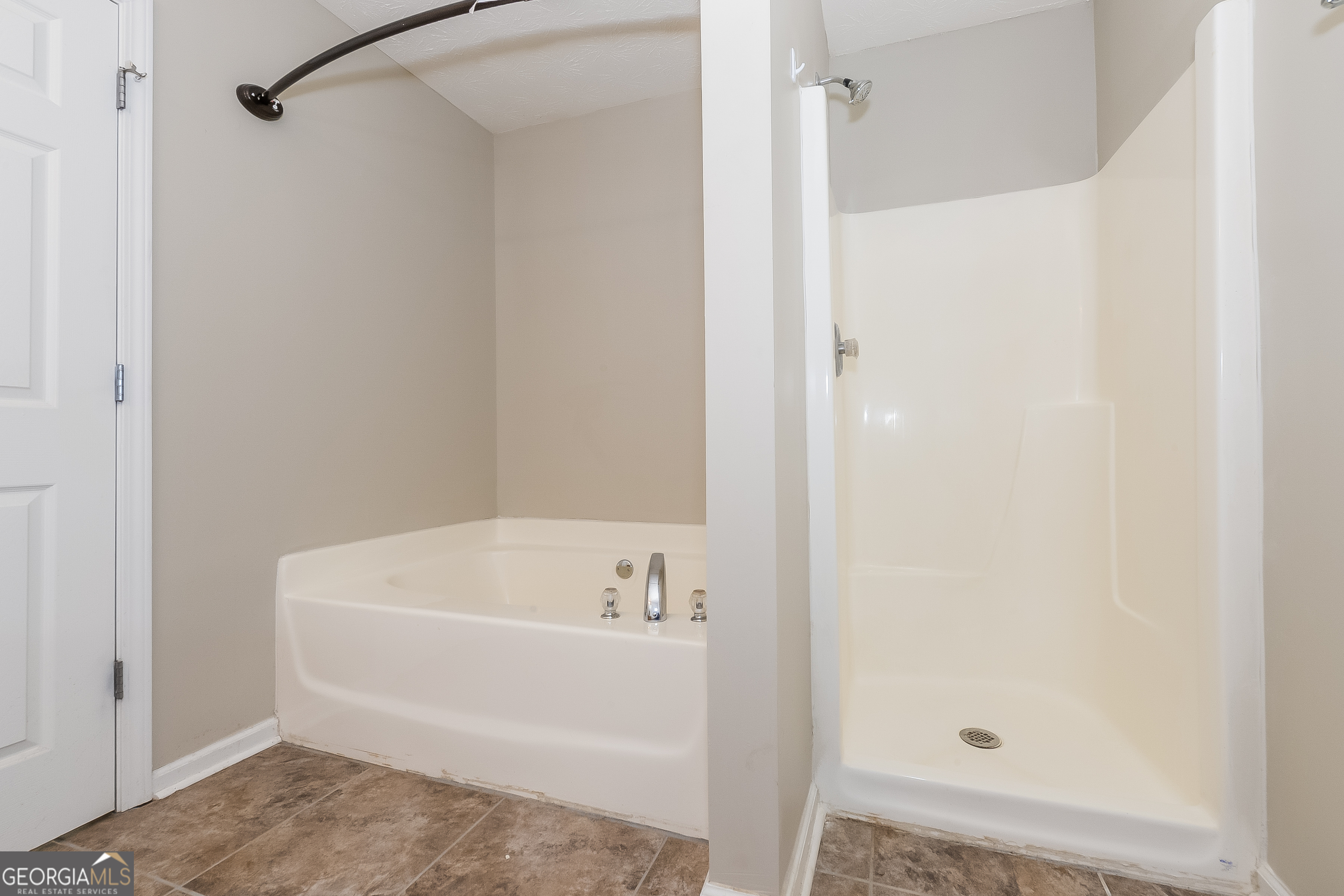 5179 Tew Lane Southwest Covington, GA 30014 - Photo 11 of 16 a bathroom with a tub and shower