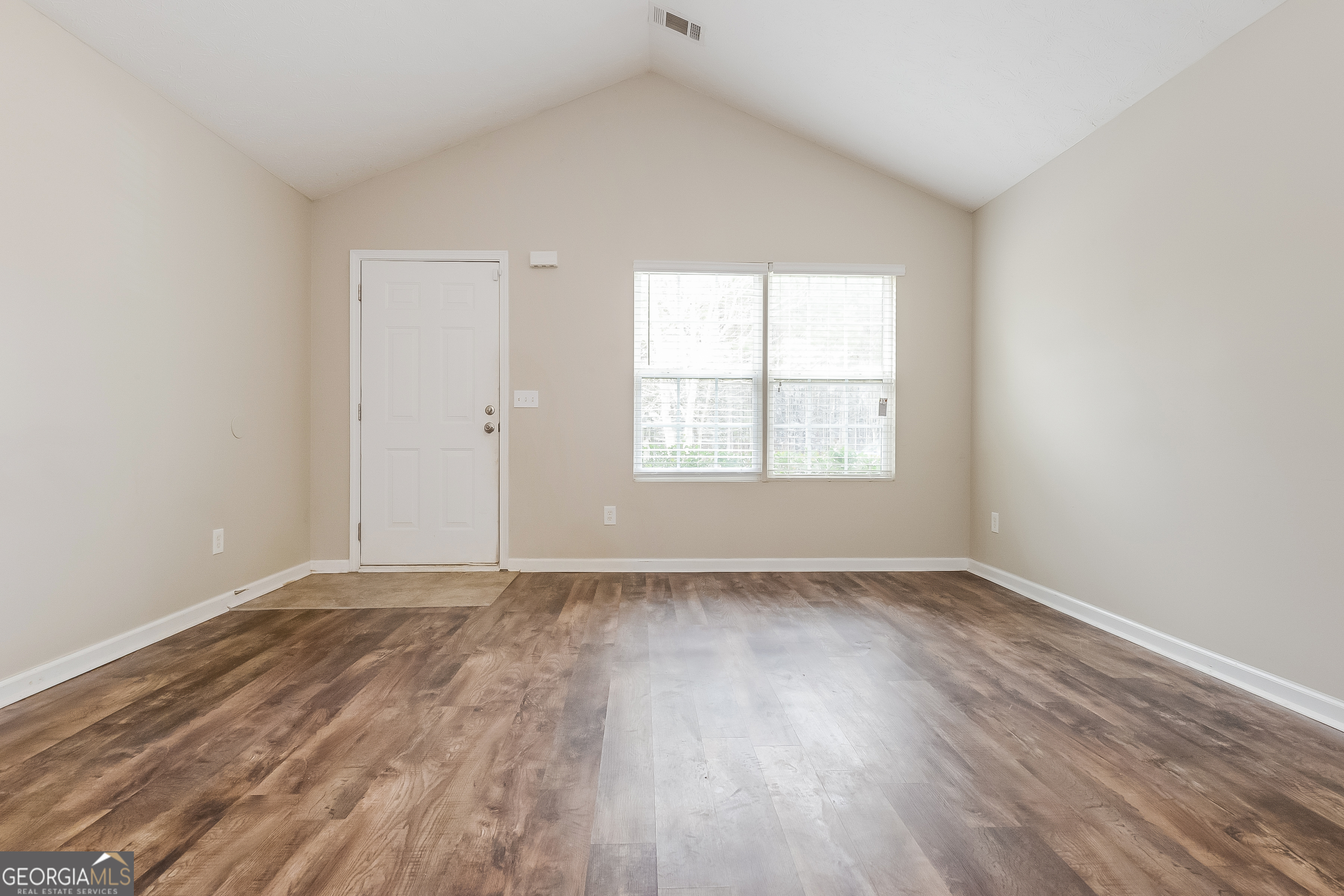 5179 Tew Lane Southwest Covington, GA 30014 - Photo 2 of 16 an empty room with wooden floor and windows