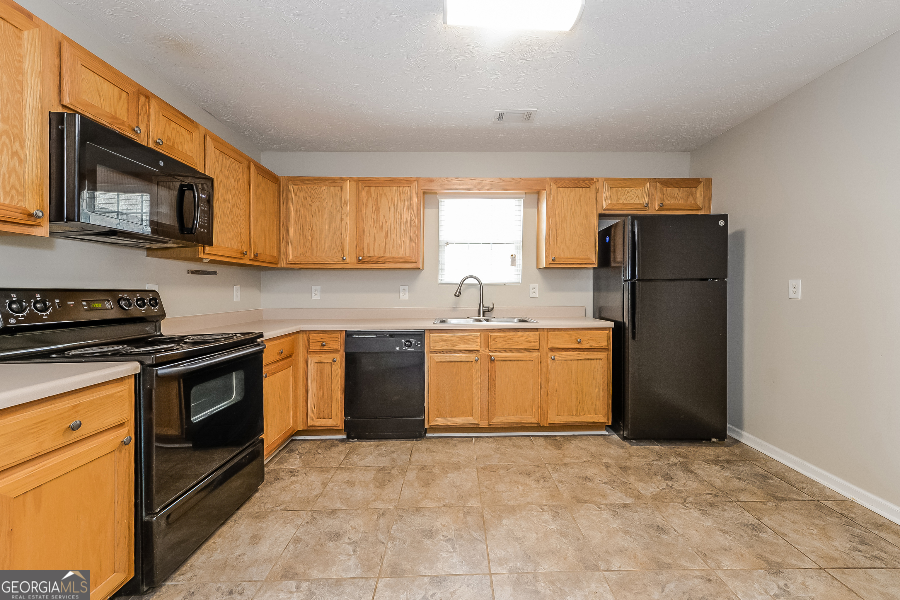 5179 Tew Lane Southwest Covington, GA 30014 - Photo 6 of 16 a kitchen with a stove a sink and a refrigerator