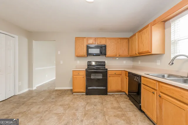 a kitchen with granite countertop a stove top oven sink and cabinets