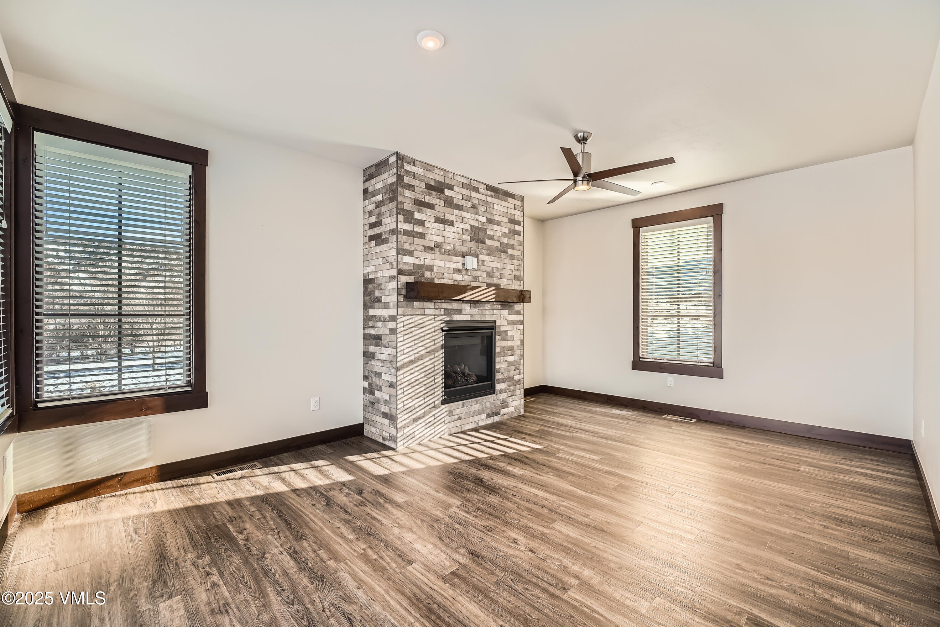 86 Hunters View Lane Eagle, CO 81631 - Photo 16 of 28 an empty room with windows a fireplace and wooden floor