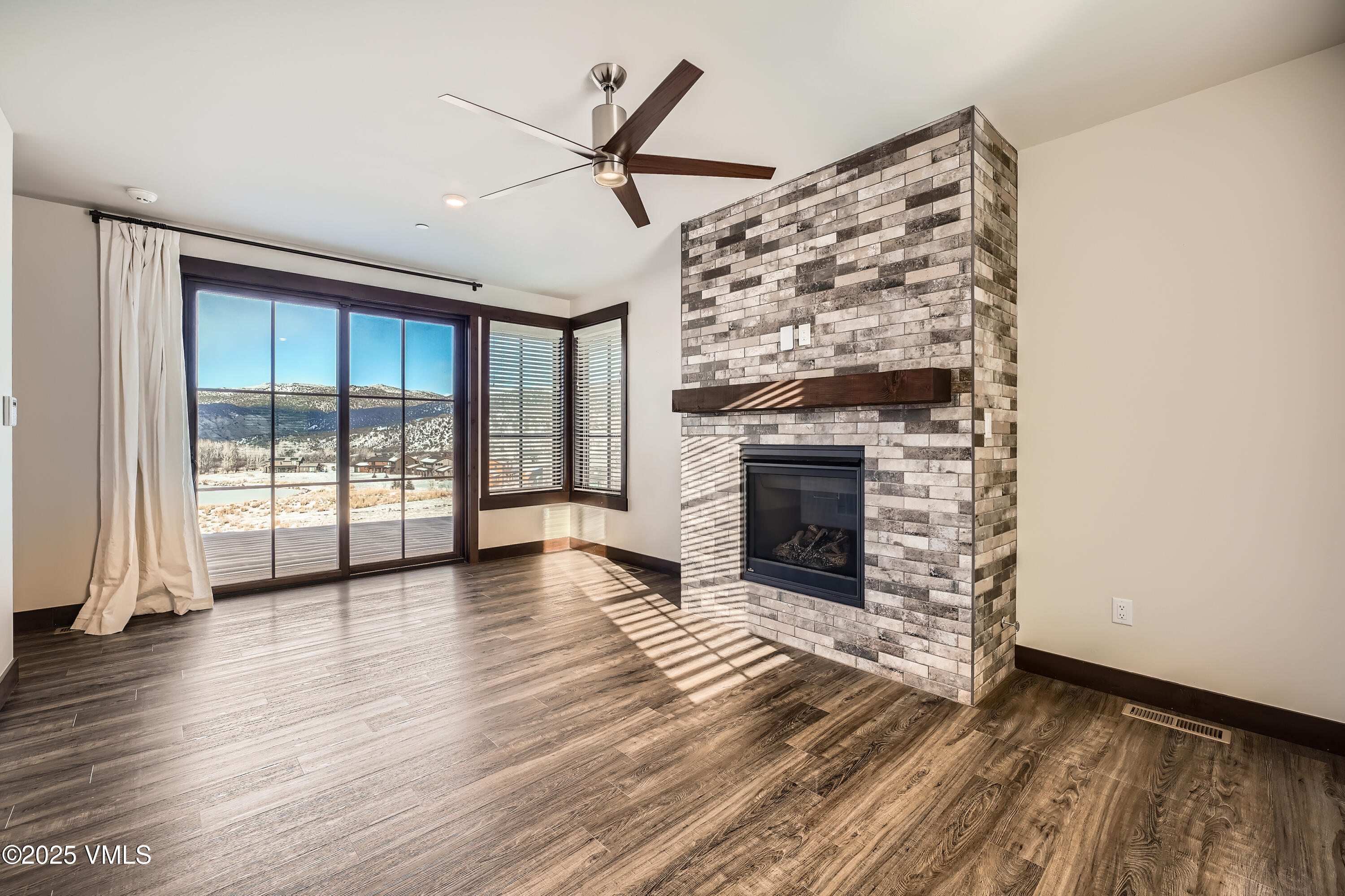 86 Hunters View Lane Eagle, CO 81631 - Photo 18 of 28 an empty room with wooden floor fireplace and windows