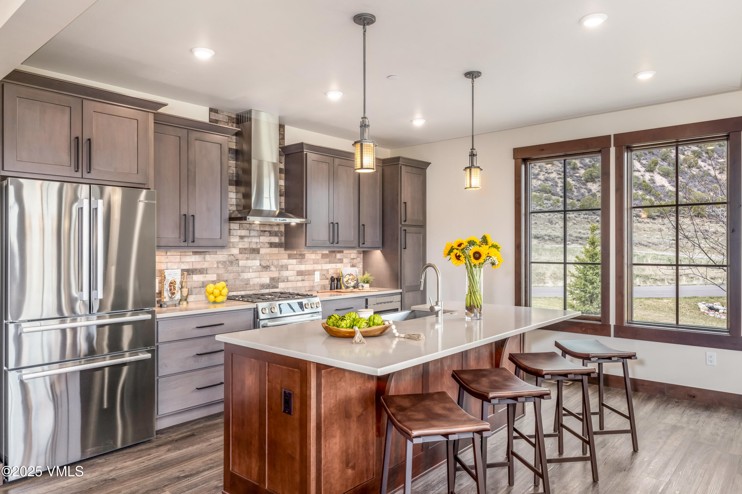 86 Hunters View Lane Eagle, CO 81631 - Photo 6 of 28 a kitchen with stainless steel appliances kitchen island granite countertop a table chairs and a refrigerator