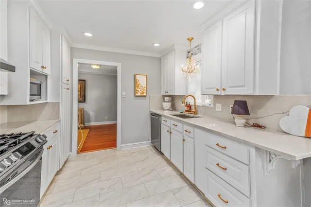 a kitchen with granite countertop a sink stove and cabinets