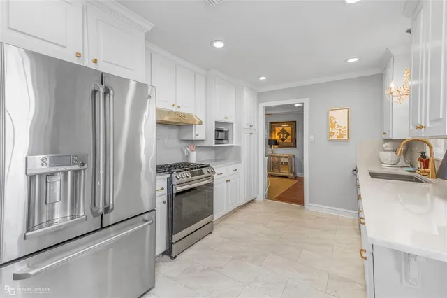 a kitchen with stainless steel appliances granite countertop a refrigerator and a stove
