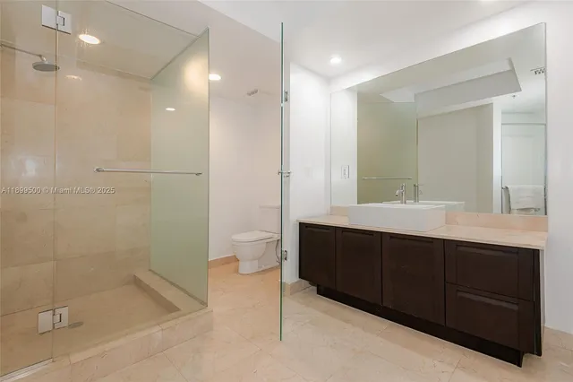 a bathroom with a double vanity sink toilet and shower