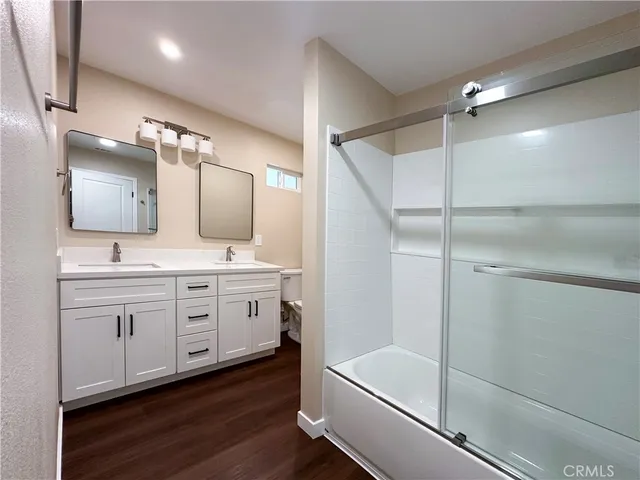 a bathroom with a double vanity sink mirror and bathtub
