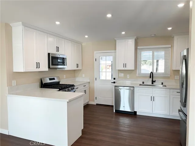 a kitchen with stove a sink and microwave