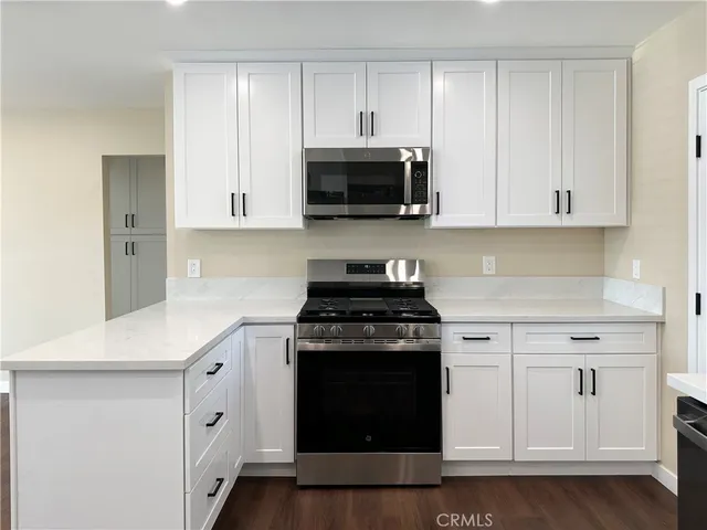 a kitchen with stainless steel appliances white cabinets and a stove a sink