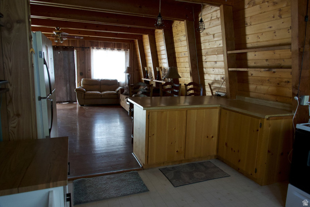 140 East Rim Road Duck Creek Village, UT 84762 - Photo 44 of 45 Kitchen with a peninsula, wooden walls, open floor plan, freestanding refrigerator, and light countertops