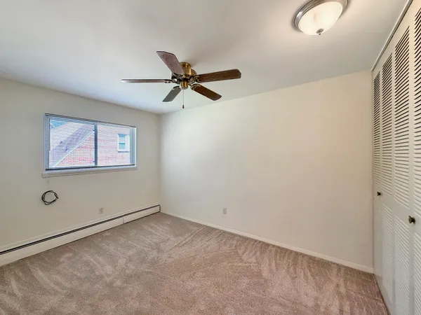 an empty room with windows and fan