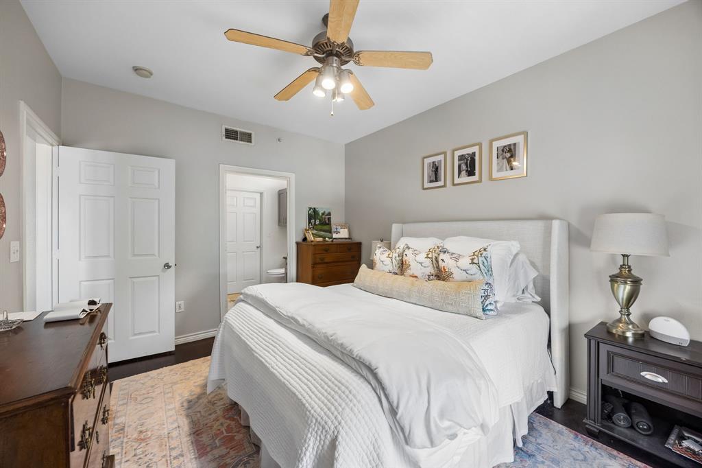 3102 Kings Road, Unit 1211 Dallas, TX 75219 - Photo 14 of 27 Bedroom featuring dark wood-finish flooring, light gray wall paint, and a ceiling fan with integrated lighting
