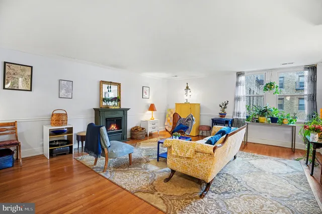 a living room with furniture a fireplace and a wooden floor