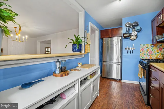 a kitchen with stainless steel appliances a refrigerator sink and wooden floor