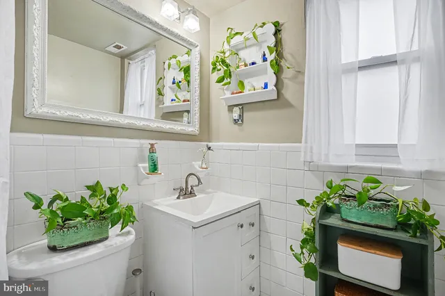 a bathroom with a sink a toilet and a window