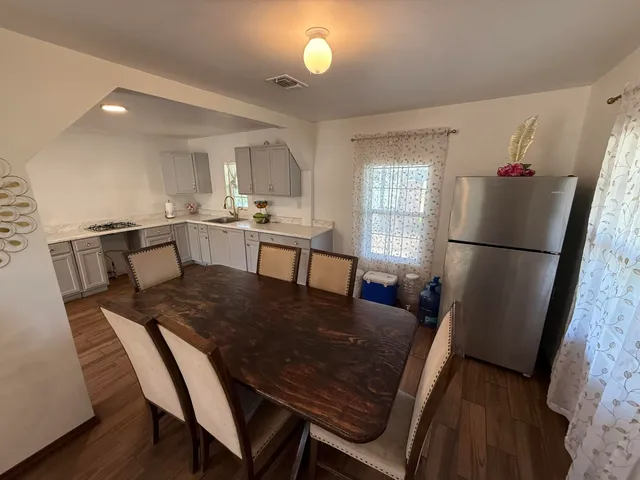 a view of a dining room with furniture and a refrigerator