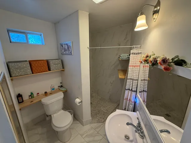 a bathroom with a sink toilet and shower