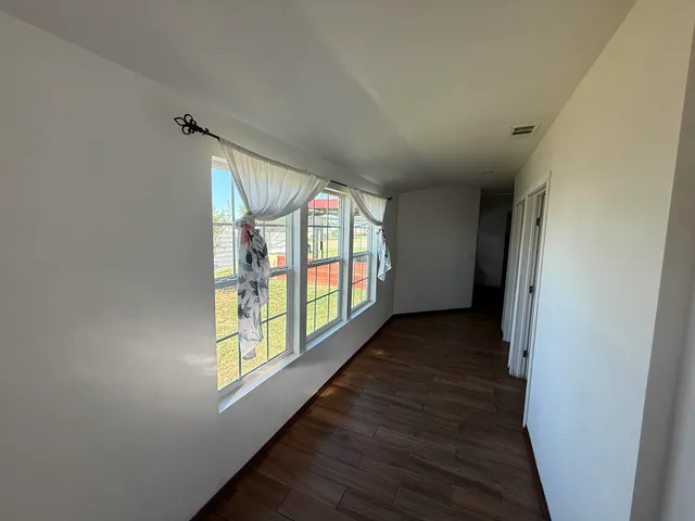 a view of hallway with wooden floor and door