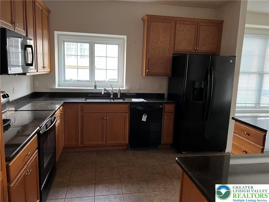 6960 Constitution Drive Bethlehem, PA 18017 - Photo 12 of 18 a kitchen with stainless steel appliances granite countertop a refrigerator a sink a stove and wooden cabinets