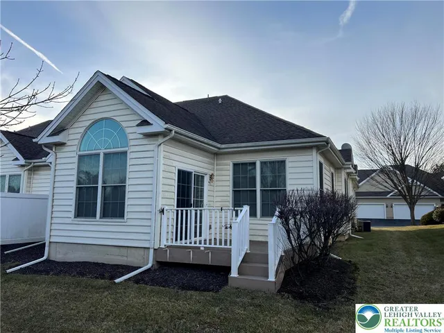 a view of a house with a yard and wooden fence
