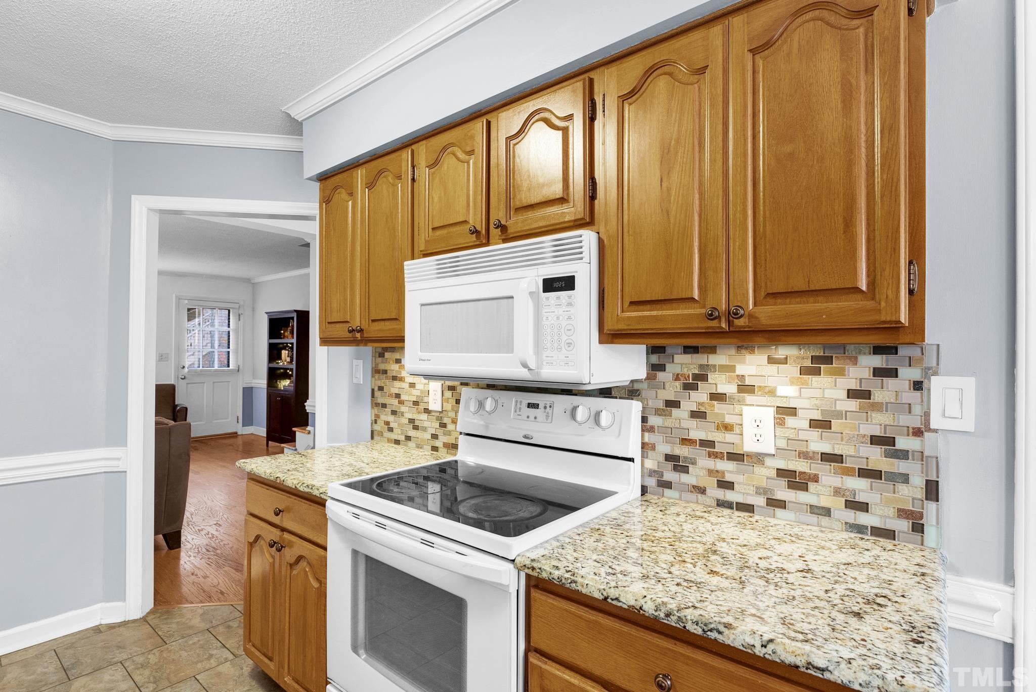 4508 Hershey Court Raleigh, NC 27613 - Photo 8 of 24 a kitchen with granite countertop cabinets washer and dryer