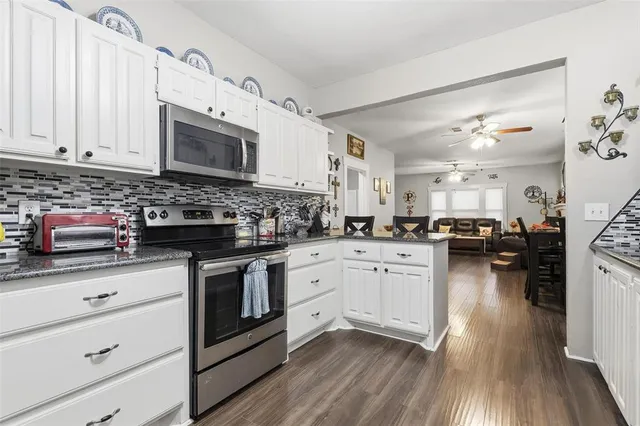 a kitchen with granite countertop white cabinets and white appliances
