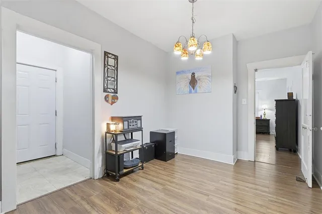 a view of a room with wooden floor and chandelier