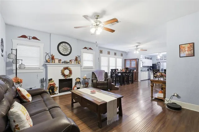 a living room with furniture kitchen view and a large window