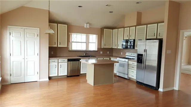 an empty room with windows and fireplace
