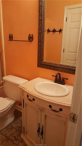 a spacious bathroom with a granite countertop sink a toilet and a mirror