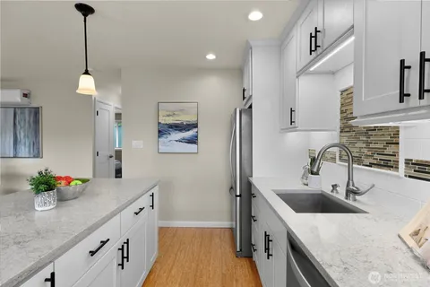 a kitchen with stainless steel appliances granite countertop a sink stove and refrigerator